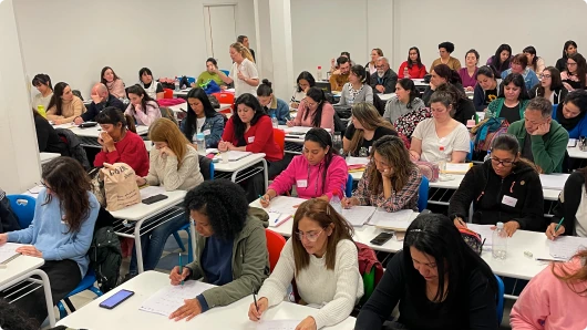 Grupo de profesores en una sesión de formación presencial, tomando notas y participando.